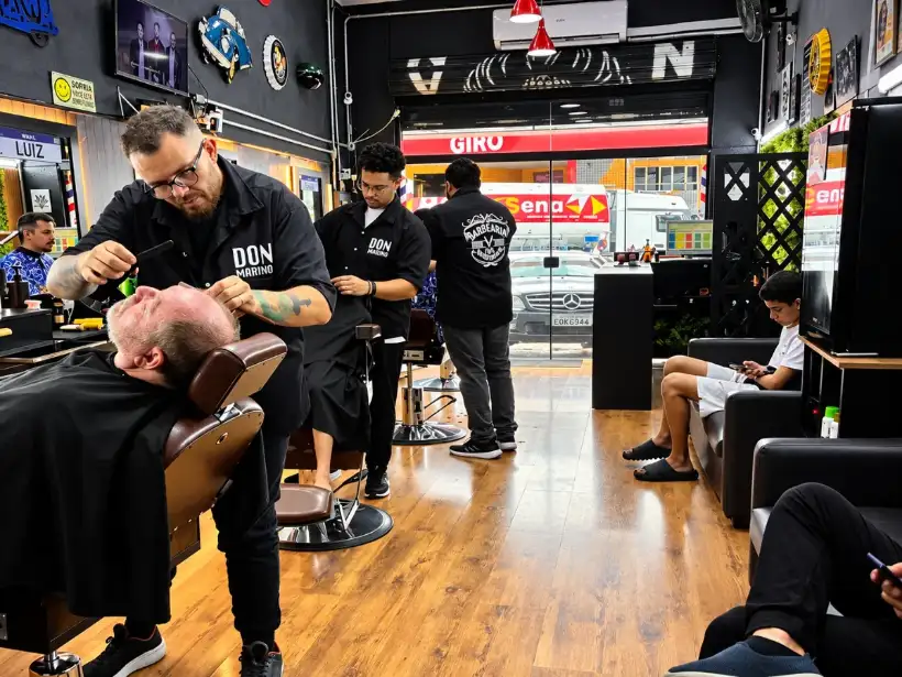 Barbeiros da Don Mariano atendendo no salão